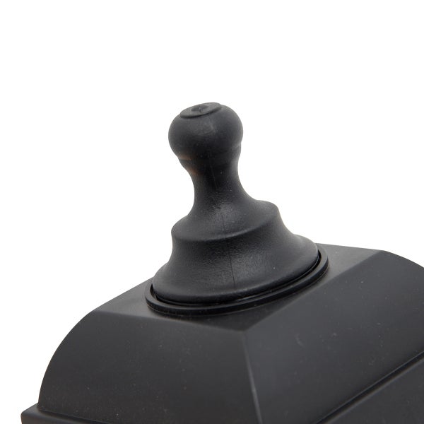 Schwarzer dekorativer Abschlussknopf aus Kunststoff auf einem quadratischen Sockel.