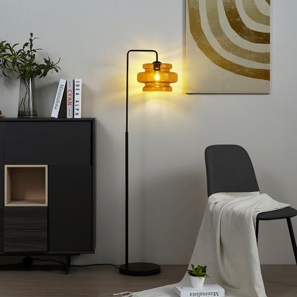 Stehleuchte mit Lampenschirm und Metallgestell in einem Wohnzimmer.