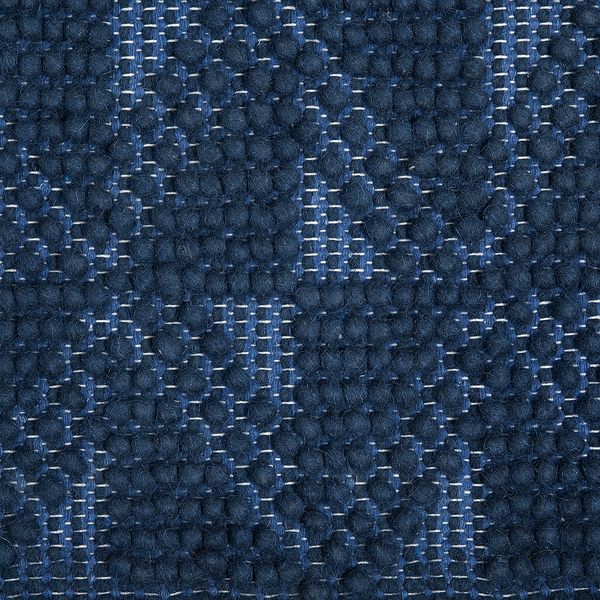 Gewebter Teppich aus Wolle in Blau mit Noppenstruktur und geometrischem Muster.