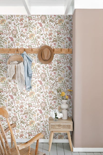 Vliestapete mit vintage Blumenmuster in einem hellen Flur mit Holzmöbeln und einer Garderobenleiste.
