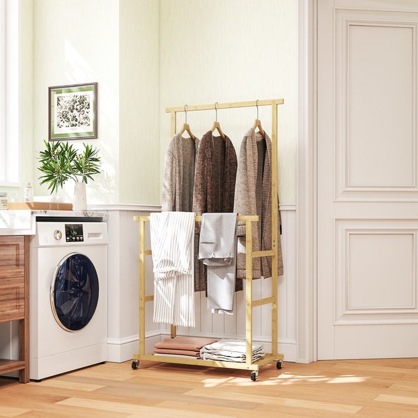 Mobiler Kleiderständer aus Bambus in einem hellen Hauswirtschaftsraum neben einer Waschmaschine, behängt mit Kleidung.