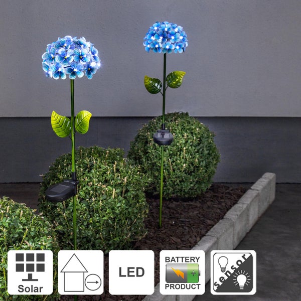 Zwei LED Solar Gartenstecker in Hortensienform zwischen Büschen