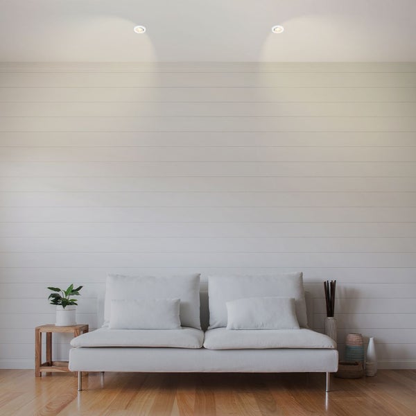 Heller Wohnraum mit Sofa, Beistelltisch und Deckenleuchten