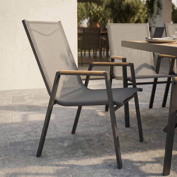 Moderner Gartentisch mit Tischplatte in Holzoptik und dunklem Metallgestell auf einer Terrasse mit Steinboden.