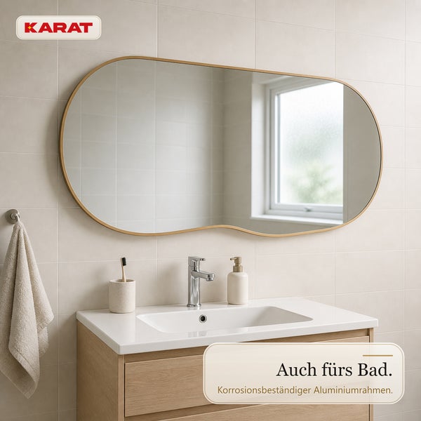 Karat Badezimmerspiegel mit unregelmaessig geformtem Aluminiumrahmen ueber einem Waschbecken in einem hellen Badezimmer.