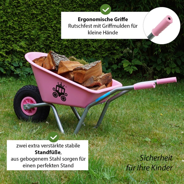 Rosa Kinderschubkarre mit Holz gefüllt auf Rasen