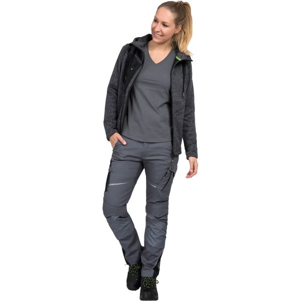 Frau in grauer Arbeitskleidung, bestehend aus einer Strickjacke mit Kapuze, einem T-Shirt und einer Arbeitshose mit Knieverstärkungen.