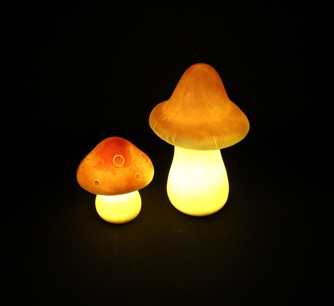 Zwei leuchtende Pilzlampen auf einem Tisch.