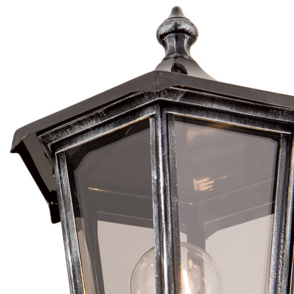 Nahaufnahme einer Außenleuchte im Laternenstil aus Metall mit Antik-Finish und klaren Glasscheiben.