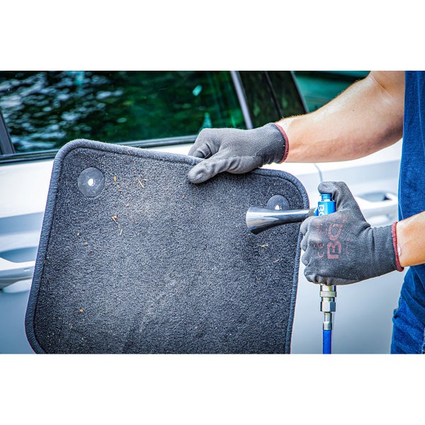 Eine Person reinigt eine Fußmatte mit einer Reinigungsmaschine.