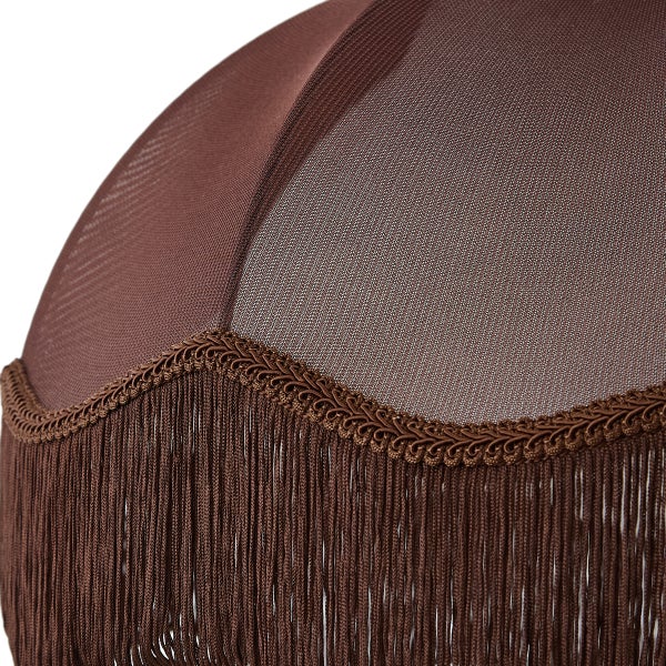 Detail eines braunen Textillampenschirms mit geschwungener Zierborte und langen Fransen.