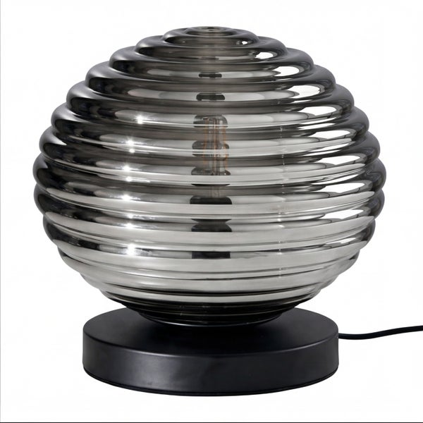 Tischleuchte mit kugelförmigem, geripptem Schirm aus Rauchglas und schwarzem Fuß.