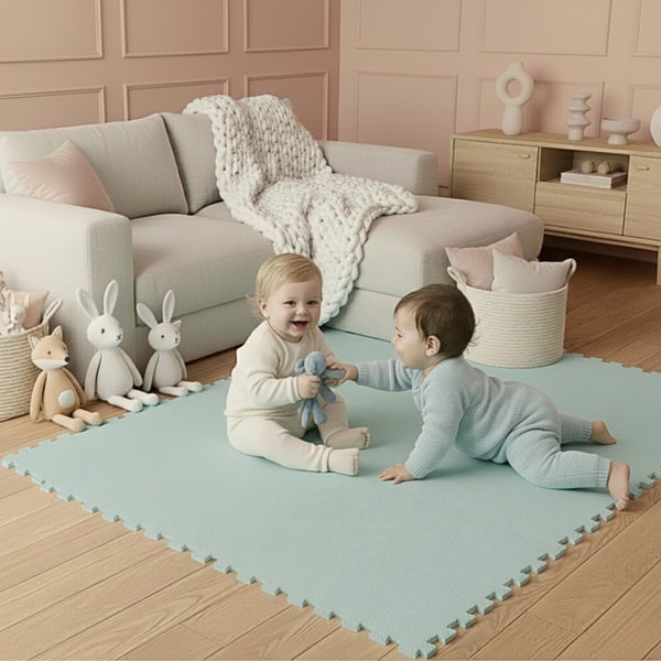 Weiche Puzzlematte für Kinder in einem hellen Wohnzimmer mit Sofa, Holzfußboden und spielenden Babys.