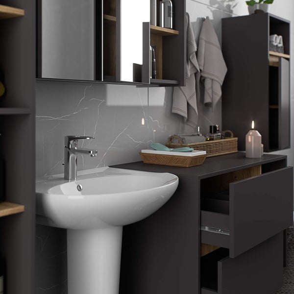 Badezimmer mit Waschbecken, Unterschrank, Spiegelschrank und Handtüchern