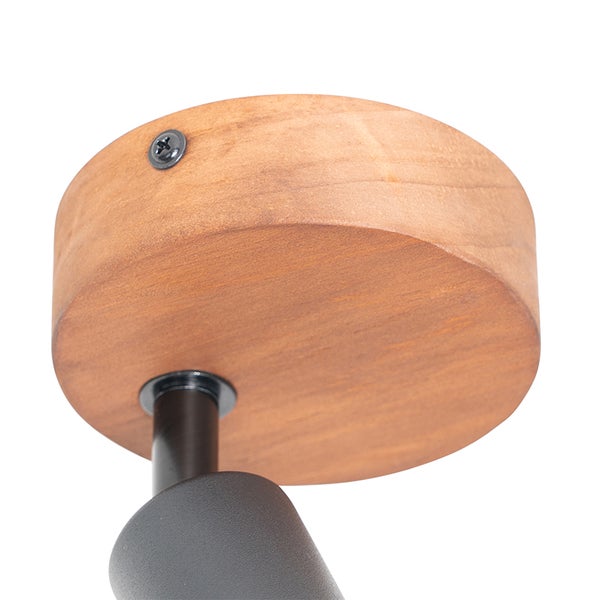 Detailansicht einer Deckenleuchte mit hölzerner Deckenbefestigung und schwarzem Lampenarm.