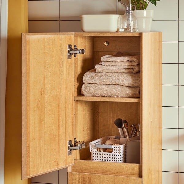 Badezimmer Hochschrank aus Holz mit geöffneter Tür, Handtüchern und Badutensilien