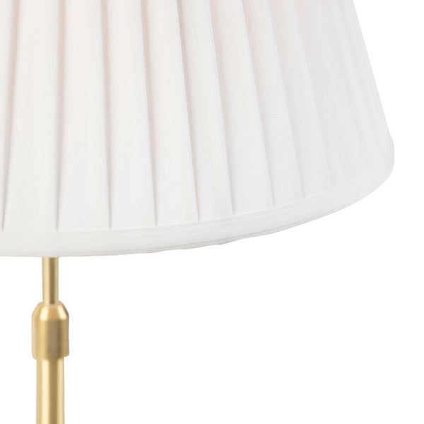 Nahaufnahme einer Leuchte mit plissiertem Lampenschirm und einem Gestell aus Metall.