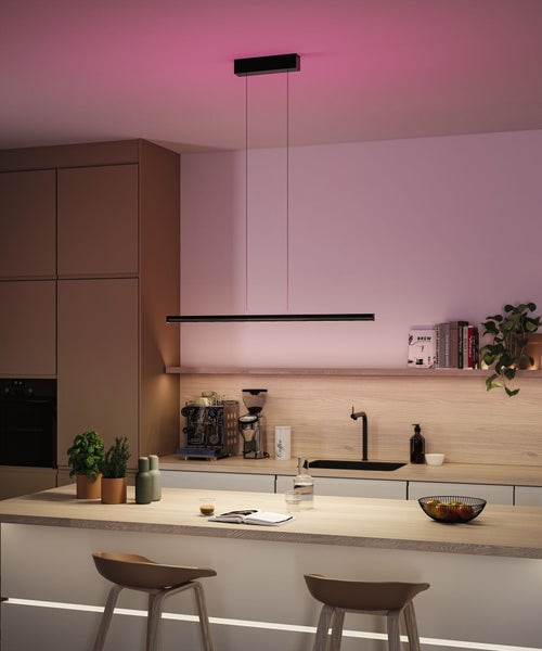 Moderne Küche mit minimalistischer schwarzer LED-Pendelleuchte über einer hölzernen Kücheninsel und indirekter Beleuchtung.
