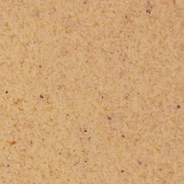 Nahaufnahme einer grobkörnigen Oberfläche von Putz oder Mörtel mit sandiger Struktur.