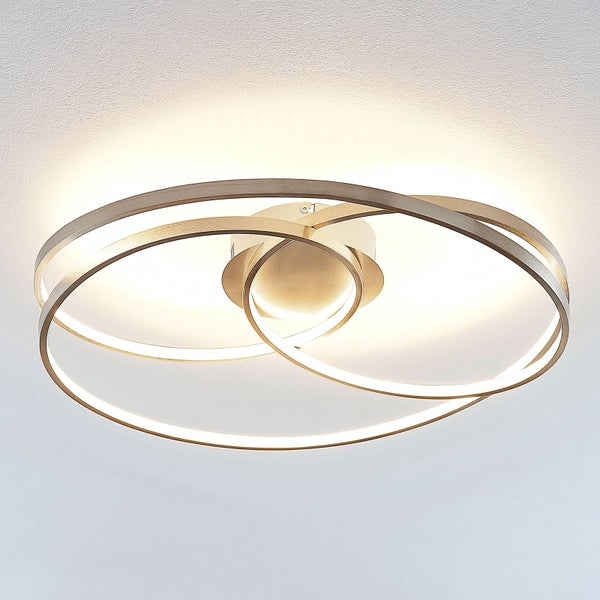 Moderne LED-Deckenleuchte mit drei ineinander verschlungenen goldfarbenen Ringen und warmweißem Licht.