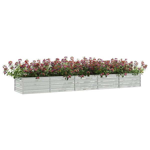 Langer rechteckiger Pflanzkasten aus Metall mit Lamellendesign, bepflanzt mit blühenden Blumen.