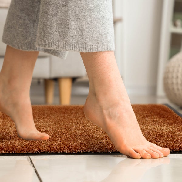 Fußmatte im Innenbereich mit Fuß darauf