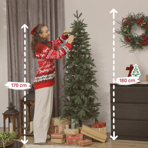 Frau schmückt künstlichen Weihnachtsbaum im Wohnzimmer, daneben Geschenke