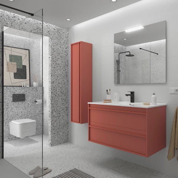 Modernes Badezimmer mit rötlichem Waschbeckenunterschrank, Hochschrank, Spiegel und Wand-WC vor Wänden mit Terrazzo-Fliesen.