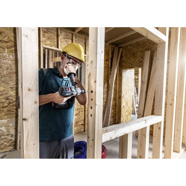 Ein Mann bohrt mit einem Akkubohrer in einen Holzrahmen