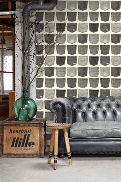 Wohnzimmer mit Jeans-Taschen-Tapete, Ledersofa und Holzhocker