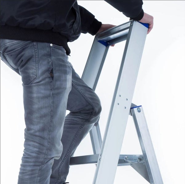 Mann steigt auf eine Aluminiumleiter