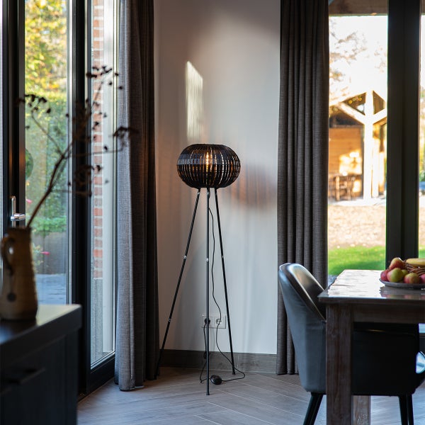 Stehlampe mit rundem Lampenschirm und Stativ im Wohnzimmer