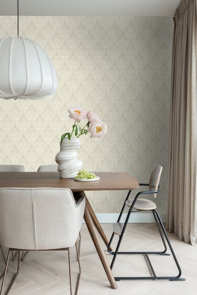 Ein Esszimmer mit einem Holztisch, Stühlen und einer gemusterten Tapete schafft eine helle und einladende Atmosphäre.