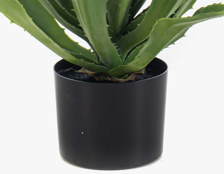 Künstlicher Kaktus mit mehreren stacheligen grünen Trieben in einem weißen Keramiktopf.