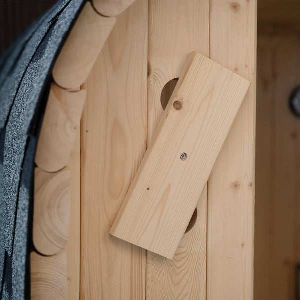 Detailansicht der Lüftungsklappe einer Holzsauna mit verstellbarem Holzschieber an der Wandverkleidung.
