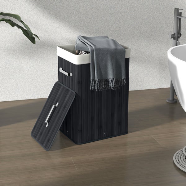 Bambus-Wäschekorb mit Deckel, Metallgriffen und Stoffeinsatz in einem hellen, modern eingerichteten Badezimmer.