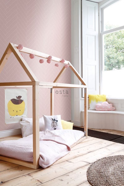 Helles Kinderzimmer mit Holzhausbett, rosa Tapete mit Fischgrätmuster und dekorativen Kissen