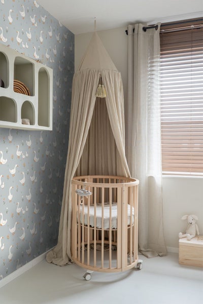 Kinderzimmer mit runden Babybett, Baldachin und Tapete mit Gänsemotiv