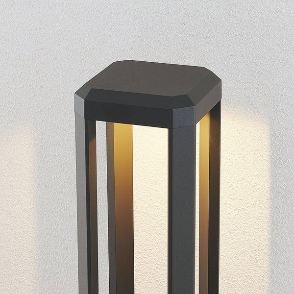 Moderne Außenleuchte in Anthrazit, quadratisches Design mit warmweißem Lichtschein vor einer strukturierten Wand.