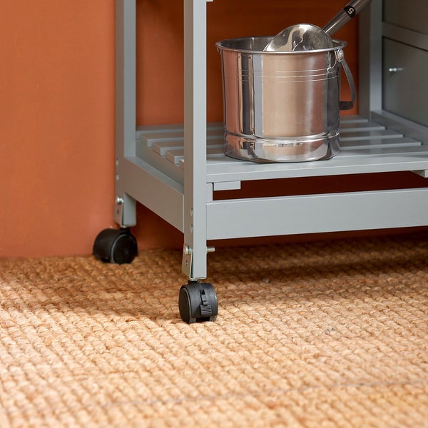 Detailansicht eines Küchenwagens mit Rollen und einem Metalleimer auf einem Regal