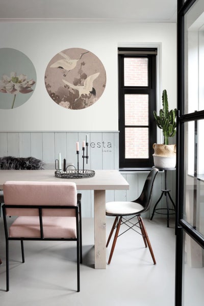 Esszimmer mit Tisch, Stühlen, Wanddekoration und Zimmerpflanze für eine helle und organisierte Atmosphäre.