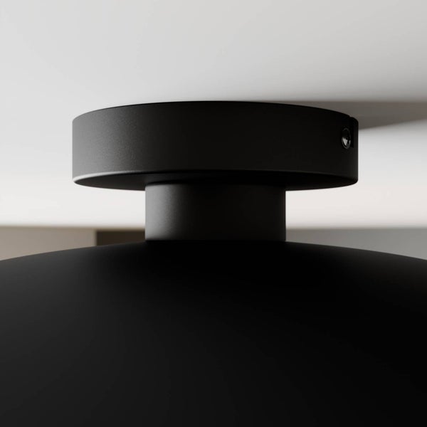 Nahaufnahme eines mattschwarzen Lampenbaldachins aus Metall an einer Decke.