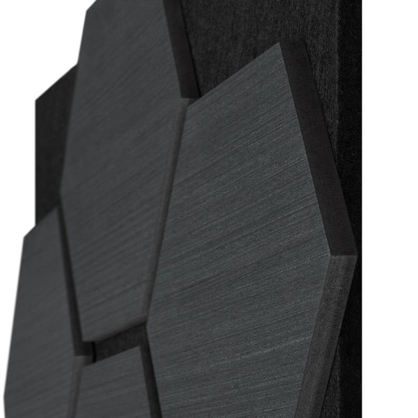 Hexagonales Wandpaneel mit Holzstruktur in Dunkelgrau auf schwarzem Filz.