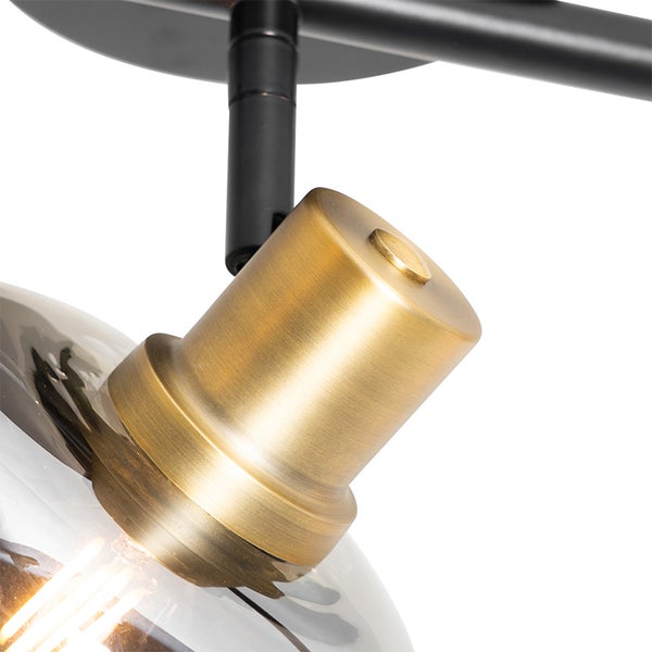 Detailansicht einer Deckenleuchte mit verstellbarem Lampenkopf und klarem Glasschirm