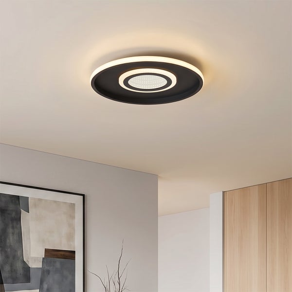 Moderne runde LED Deckenleuchte mit zwei Lichtringen in einem Wohnraum.