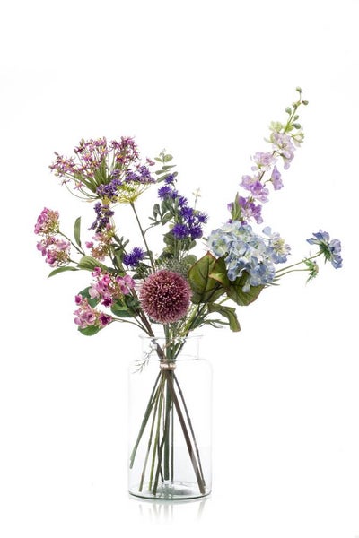 Künstlicher Blumenstrauß in einer Glasvase mit verschiedenen Blumen wie Hortensien, Allium und Rittersporn.