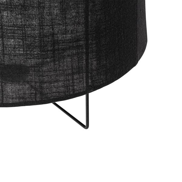 Detailansicht einer Lampe mit schwarzem Textilschirm und schwarzem Metallgestell.