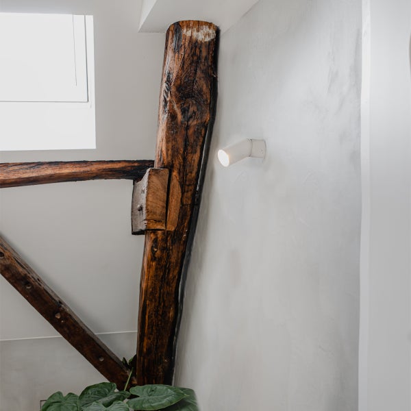 Innenraum mit Holzbalken und Wandleuchte