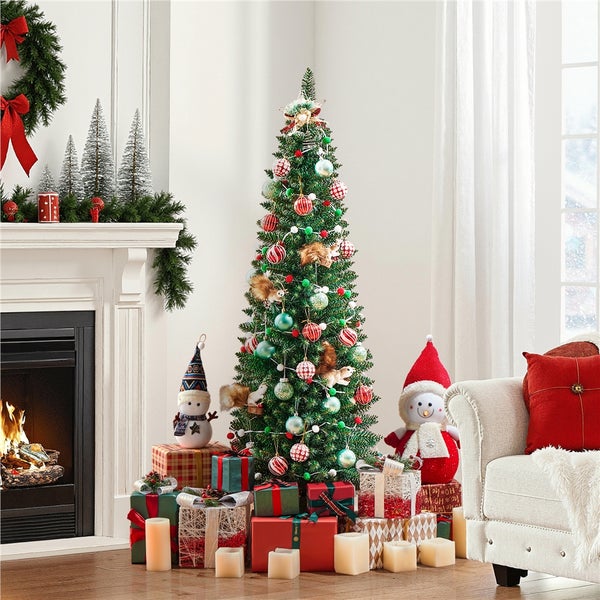 Weihnachtlich dekorierter Wohnraum mit beleuchtetem Weihnachtsbaum, Geschenken und Kamin.