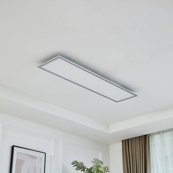 Rechteckiges LED-Panel an einer weißen Decke in einem hellen Wohnraum, flaches Design mit silbernem Rahmen.